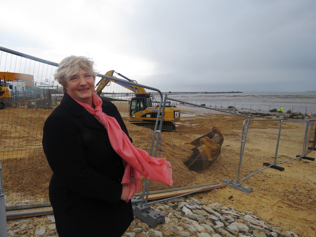Cllr Mary Betson at the Three Shells Beach, where the lagoon is being built, with the first rocks of the lagoon being laid in the background.